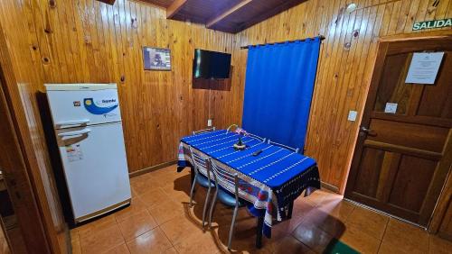 a kitchen with a blue table and a refrigerator at Cabañas Rincon Santa Maria in Puerto Iguazú