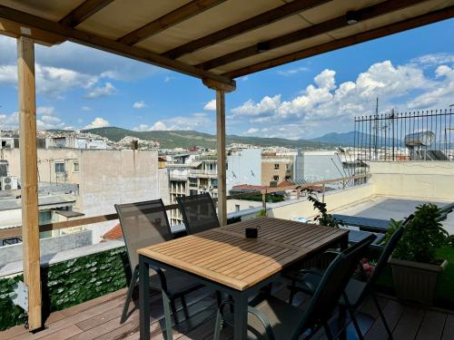 テッサロニキにあるRooftop Mini Suite-Roof Deck-Sunbeds-City viewの眺めの良いバルコニーにテーブルと椅子が置かれている