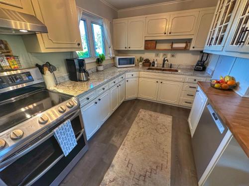 a kitchen with white cabinets and a counter top at Brittany Motel in Sunderland
