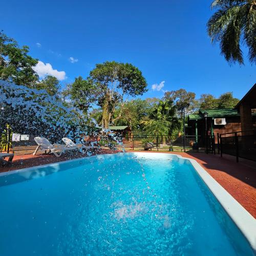 a swimming pool with blue water in a yard at Cabañas Rincon Santa Maria in Puerto Iguazú