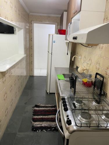 a kitchen with a stove and a refrigerator at Excelente AP na Orla de Ubatuba in Ubatuba