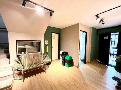 a living room with a couch in a room with green walls at Alquiler apartamento amoblado en Laureles NID201 By Roots Rentals in Medellín