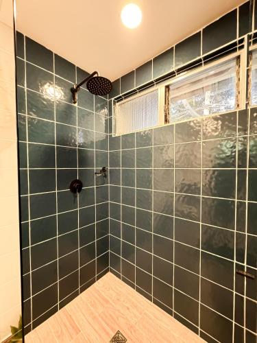 a bathroom with a shower with green tiled walls at Alquiler apartamento amoblado en Laureles NID201 By Roots Rentals in Medellín
