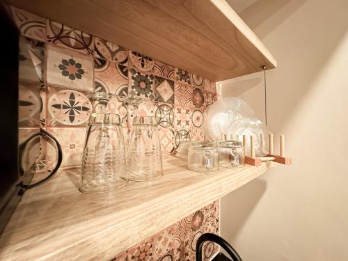 a shelf filled with glass vases on a wall at Alquiler apartamento amoblado en Laureles NID201 By Roots Rentals in Medellín