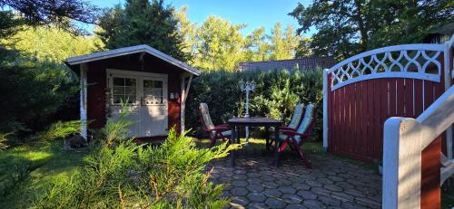 a small shed with a table and chairs in a garden at Ferienhaus FH6 in Graal-Müritz