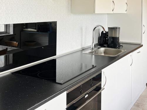 a kitchen with a sink and a black counter top at 5 person holiday home in Sydals in Trænge