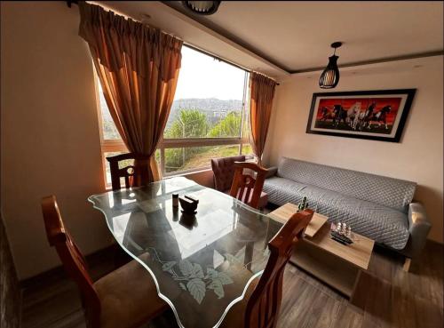 a living room with a glass table and a couch at Excelente ubicación como en casa tranquilidad in Villamaría