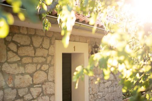 a stone house with a door and a stone wall at Villa Madunic with private swimming pool in Cista Provo
