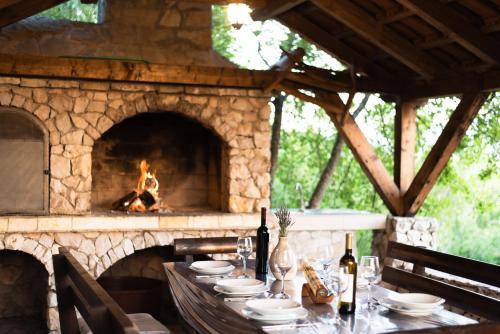 a table with a fireplace in front of a table with glasses at Villa Madunic with private swimming pool in Cista Provo