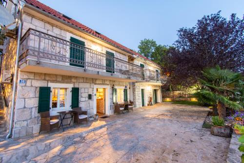 an old house with a balcony and a courtyard at Villa Madunic with private swimming pool in Cista Provo