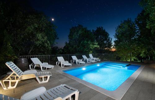 a swimming pool with chaise lounge chairs and a swimming pool at Villa Madunic with private swimming pool in Cista Provo