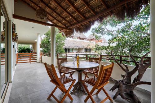 un patio avec une table et des chaises sur un balcon dans l'établissement Beautiful Penthouse with Private Rooftop and Hot Tub, à Tulum