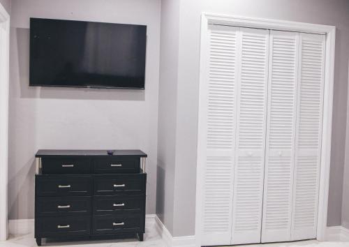 a bedroom with a flat screen tv and a dresser at Island Haven Hideaway 1BR in Nassau