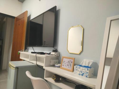 a room with a mirror and a desk with a computer at Zhuge Hospitality Homestay in Tainan