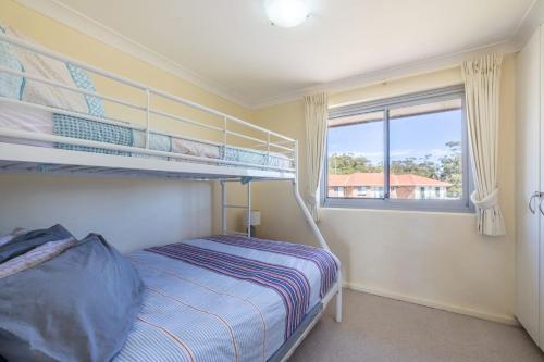 a bedroom with two bunk beds and a window at Luskin Lodge 11 stunning water views in Shoal Bay