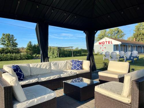 un patio con sofás y sillas bajo un cenador en Best Motel Bowling Green, en Bowling Green