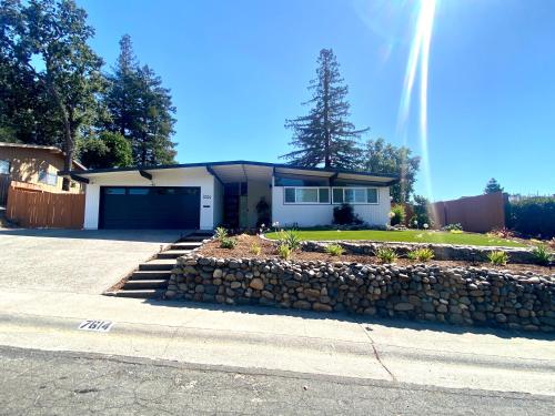 a house with a stone wall in front of it at NEW cozy beautiful house with pool and hot tub in Fair Oaks