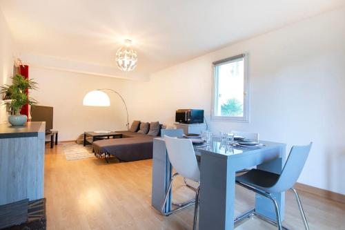 un salon avec un canapé, une table et des chaises dans l'établissement Alden Park - T3 Spacieux et Agréable, à Nantes