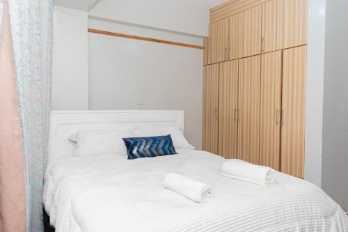 a bedroom with a white bed with two towels on it at Golden Nest in Lake View Estate