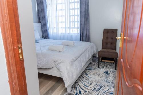 a small bedroom with a bed and a chair at Golden Nest in Lake View Estate