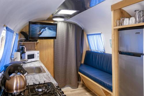 a kitchen with a couch and a sink and a tv at Cowabunga in Fort Bragg