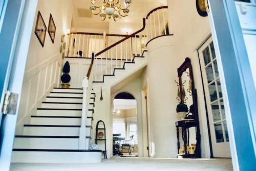 a hallway with white stairs and a chandelier at Pinkies Place-Hot Tub-Sleeps 11-Pet Friendly in Ahwahnee