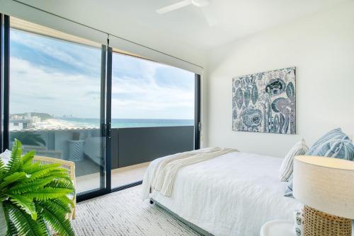 a bedroom with a bed and a view of the ocean at Sable Penthouse at Palm Beach's Waterfront in Gold Coast