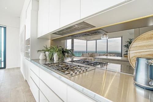 a kitchen with a counter with a stove top oven at Sable Penthouse at Palm Beach's Waterfront in Gold Coast
