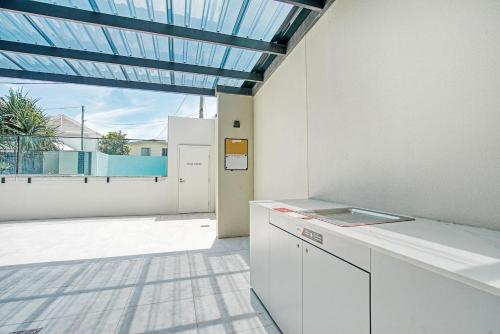 a kitchen with a large window with a view of a patio at Sable Penthouse at Palm Beach's Waterfront in Gold Coast