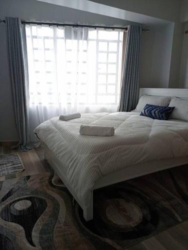 a bedroom with a large bed with a large window at Golden Nest in Lake View Estate