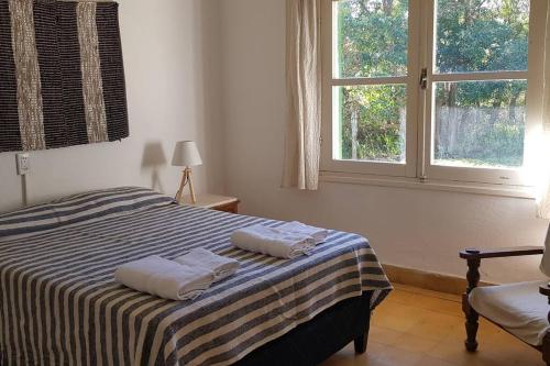 ein Schlafzimmer mit einem Bett mit zwei Handtüchern darauf in der Unterkunft Casa de playa, rodeada de monte, campo y mar in La Coronilla