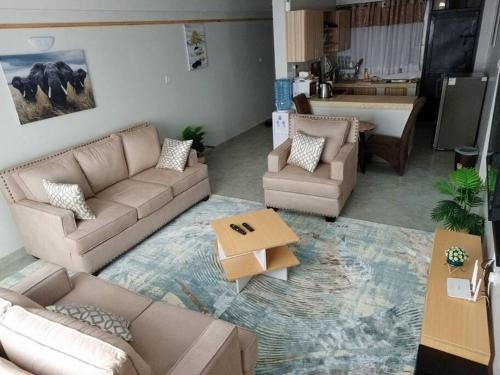 a living room with a couch and chairs and a table at Golden Nest in Lake View Estate