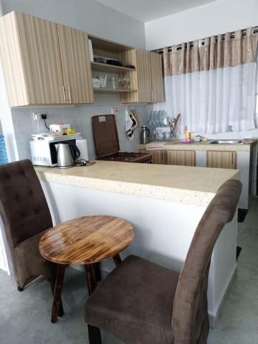 a kitchen with a counter and a table and chairs at Golden Nest in Lake View Estate