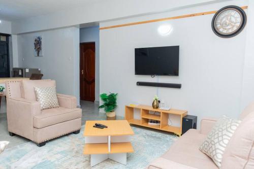 a living room with a couch and a tv at Golden Nest in Lake View Estate