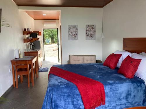 a bedroom with a bed and a desk and a kitchen at Villas Santa Maria - Private Bay Lake Arenal in Nuevo Arenal