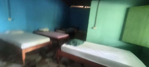 une petite chambre avec deux lits et une table dans l'établissement Hostel María Ometepe, à Santa Cruz