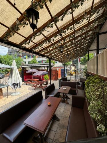 a patio with a wooden table and benches at Bridge Park Hotel in London