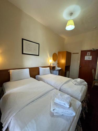 two beds in a hotel room with white sheets at Bridge Park Hotel in London