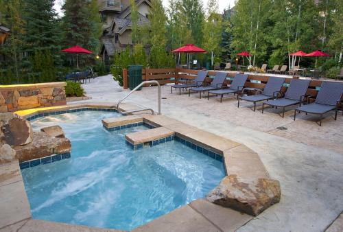 Una gran piscina con sillas y una mesa. en Aspenwood 311 condo, en Edwards