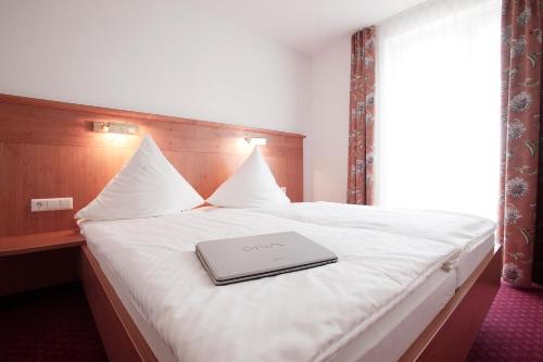 a laptop on a bed in a hotel room at Hotel Hirsch in Kehl am Rhein