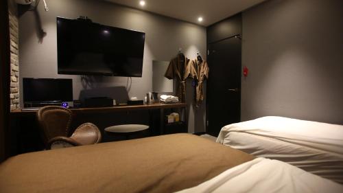 a hotel room with a bed and a flat screen tv at Hotel Avant in Cheonan