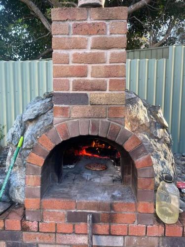 a brick oven with a pizza inside of it at Tasman Sea View Bonny Hills in Bonny Hills
