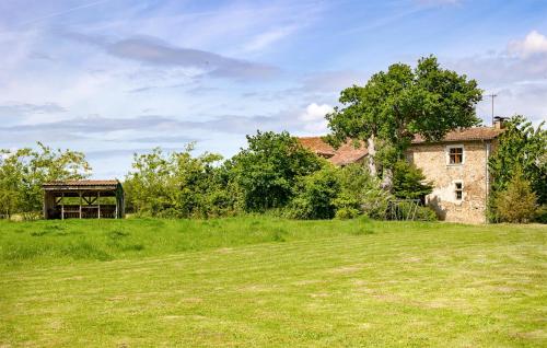an old stone building in a field next to a tree at Stunning Home In Ossages in Ossages