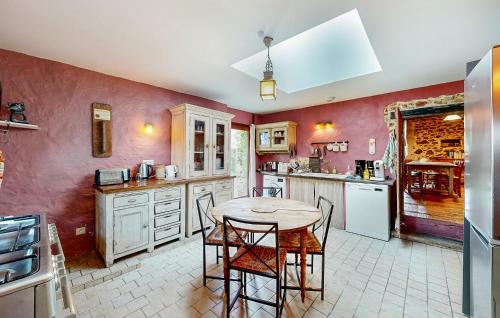 a kitchen with pink walls and a table and chairs at Stunning Home In Ossages in Ossages