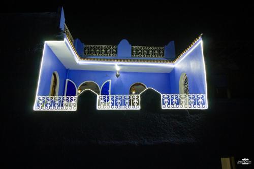 a blue building with a balcony at night at Casa Sanae in Chefchaouene