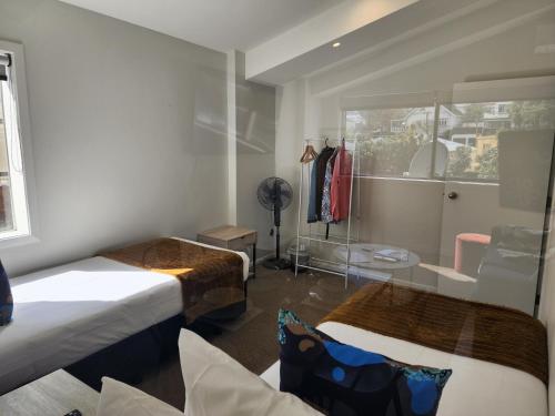 a room with two beds and a window at U Suites Kilbirnie in Wellington