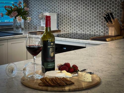 a bottle of wine and a glass of wine and cheese at River Walk in Wynyard in Wynyard