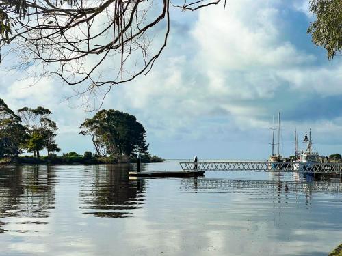 a man on a boat in the water near a bridge at River Walk in Wynyard in Wynyard