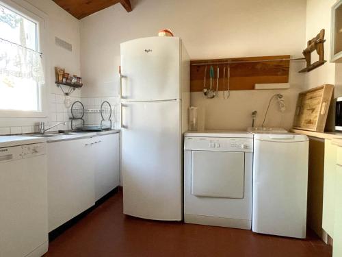 Il comprend une cuisine équipée d'appareils électroménagers blancs et d'un réfrigérateur blanc. dans l'établissement Maison 4 pièces près mer et port La Palmyre - 7 pers., WiFi, animaux OK, parking, patio, ménage inclus - FR-1-705-36, aux Mathes