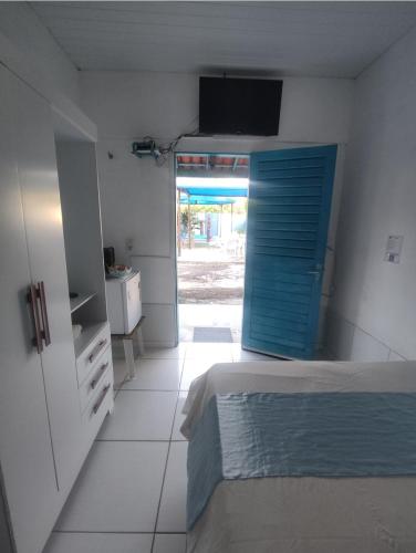 a bedroom with a bed and a blue door at Hospedagens Icapui Mare Blu in Icapuí